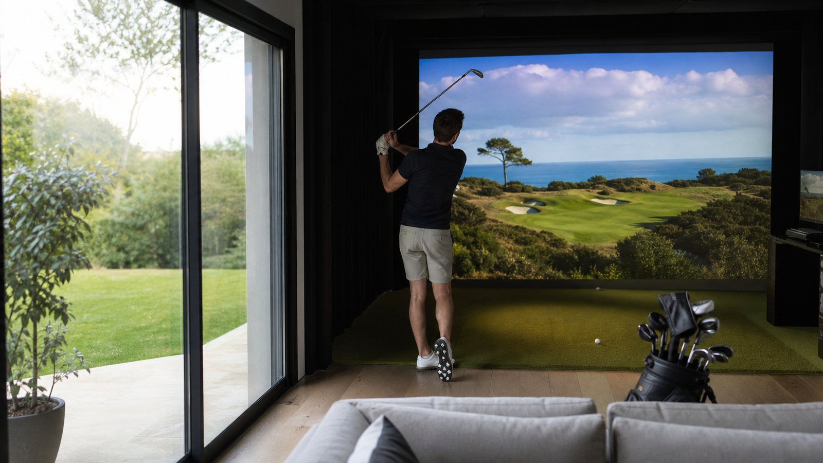Salle de simulateur de golf indoor haut de gamme chez un particulier, écran tendu et assises en cuir