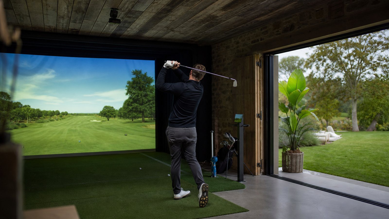 Simulateur de golf indoor haut de gamme installé dans une pièce dédiée aux teintes sobres
