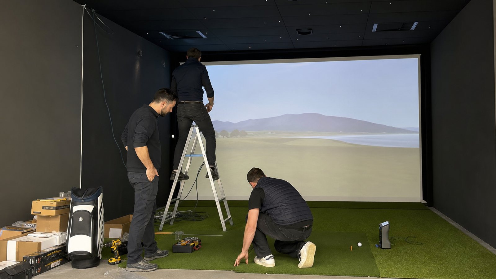 Écran d'impact et structure d'un simulateur de golf en cours de montage dans une pièce dédiée