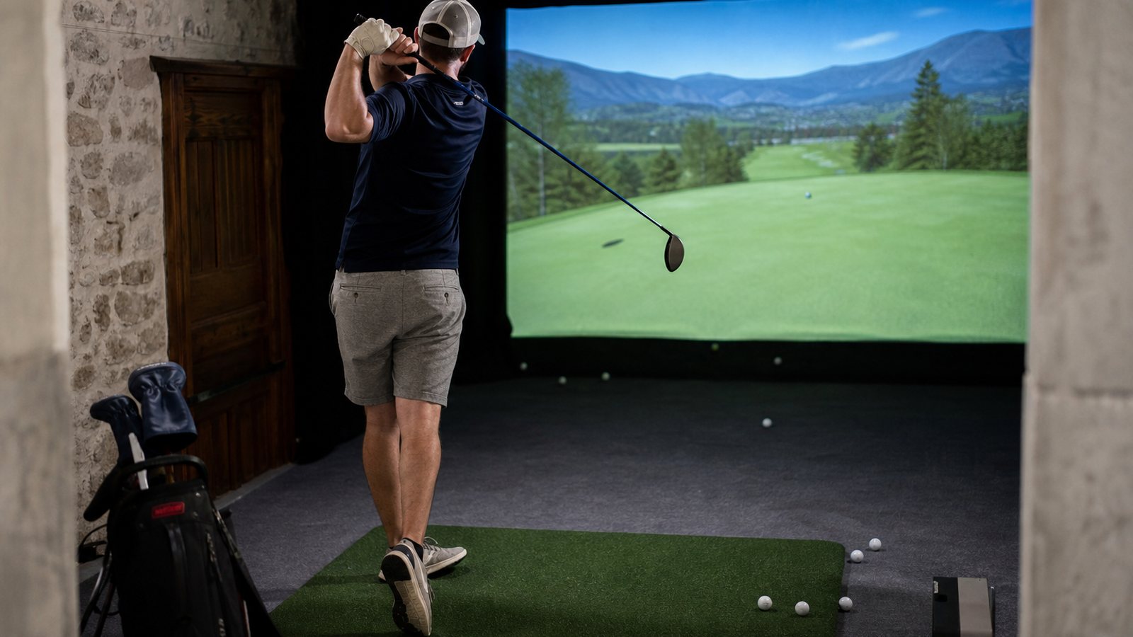 Golfeur analysant les données de son swing affichées sur l'écran d'un simulateur indoor